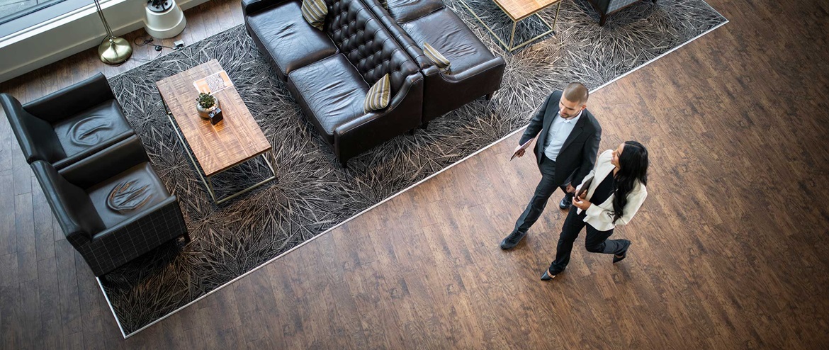 Two business professionals walking and talking in a modern office lobby