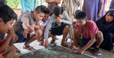 Group of people crouched down looking at a map