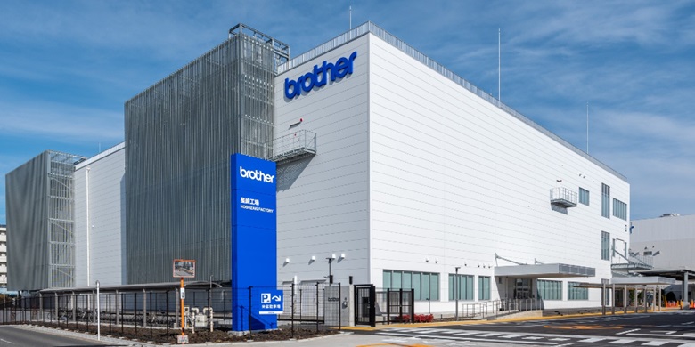 White and grey Brother factory building with a blue sky