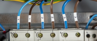 A top-down view of six alternating brown and blue cables labelled in pairs with 